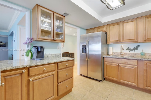 kitchen featuring light stone countertops, light tile patterned flooring, sink, stainless steel fridge, and ornamental molding