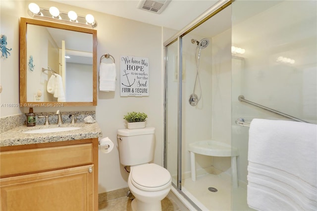 bathroom with vanity, toilet, walk in shower, and tile patterned flooring