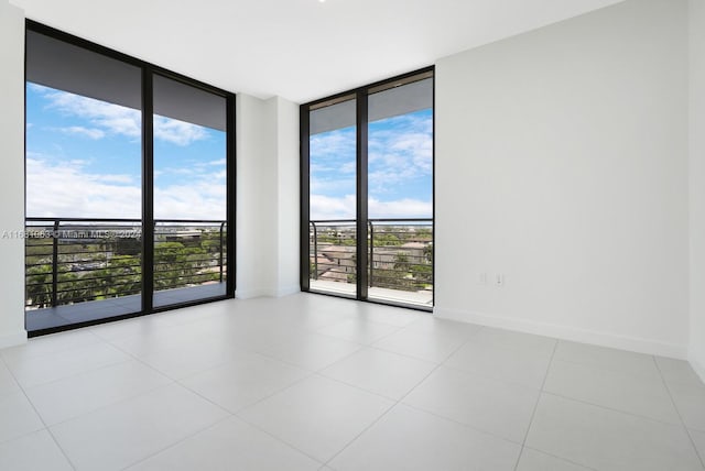 tiled spare room featuring expansive windows