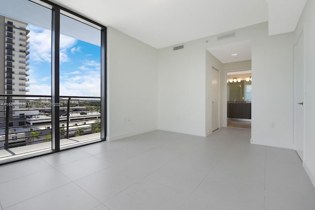 tiled spare room featuring floor to ceiling windows