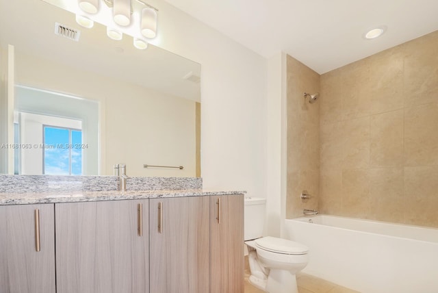 full bathroom with tiled shower / bath, vanity, and toilet