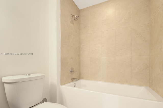 bathroom with tiled shower / bath combo and toilet