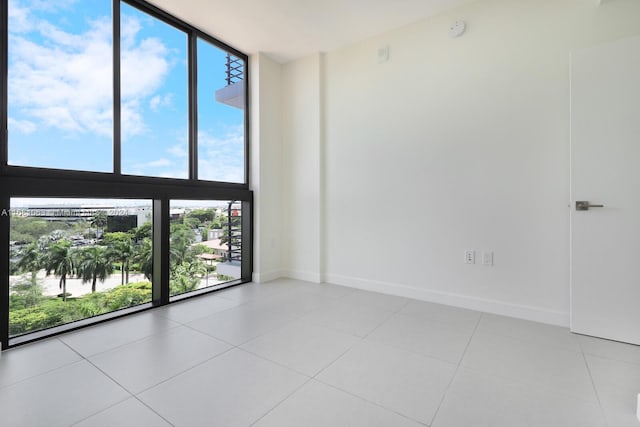 tiled empty room with plenty of natural light and floor to ceiling windows