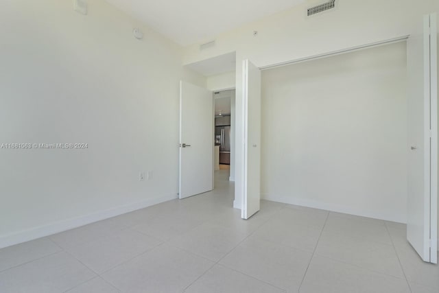 unfurnished bedroom featuring a closet and light tile patterned floors