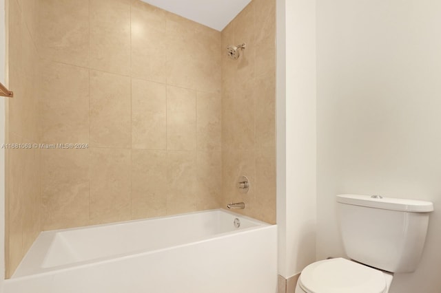 bathroom with toilet and tiled shower / bath