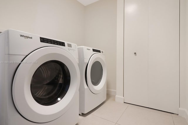 clothes washing area featuring independent washer and dryer and light tile patterned floors