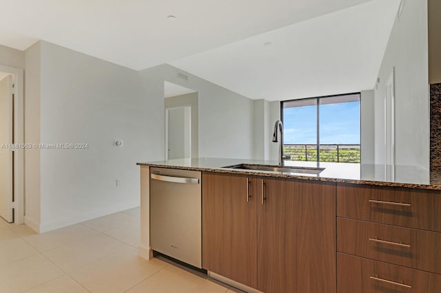 kitchen featuring sink, dishwasher, light tile patterned flooring, and dark stone countertops