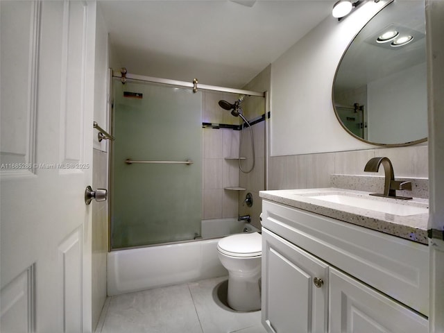 bathroom with tile patterned flooring, shower / bath combination with glass door, vanity, and toilet