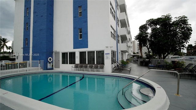 pool with a patio and fence