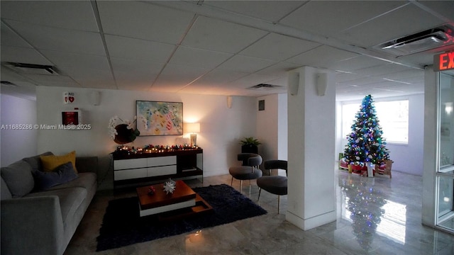 living room with a drop ceiling and visible vents