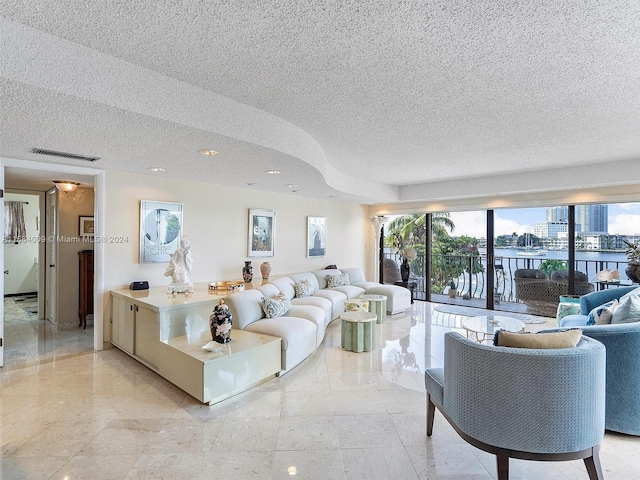 living room with a textured ceiling, plenty of natural light, and a water view