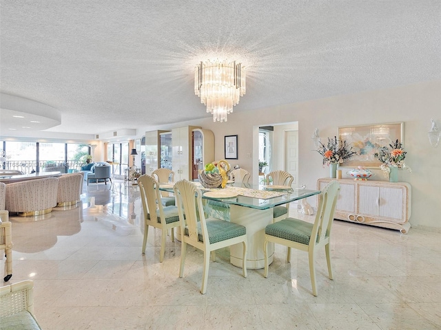 dining room featuring a chandelier and a textured ceiling