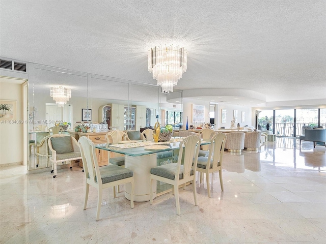 dining space with a textured ceiling and an inviting chandelier