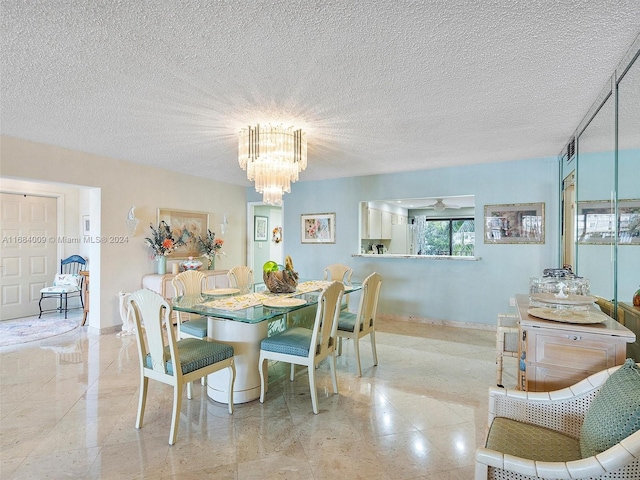 dining area featuring ceiling fan with notable chandelier and a textured ceiling