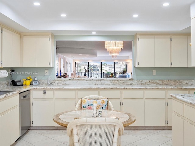 kitchen with dishwasher, a tray ceiling, an inviting chandelier, and cream cabinetry