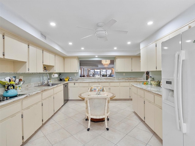 kitchen with sink, ceiling fan, white fridge with ice dispenser, stainless steel dishwasher, and cream cabinetry