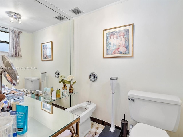 bathroom with toilet, a bidet, and crown molding