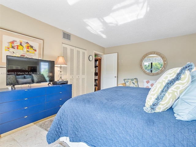 bedroom featuring a textured ceiling and a closet