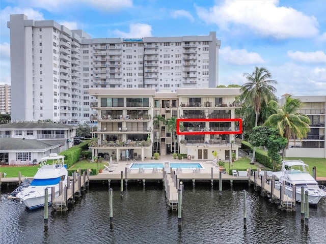 view of building exterior featuring a water view and a community pool