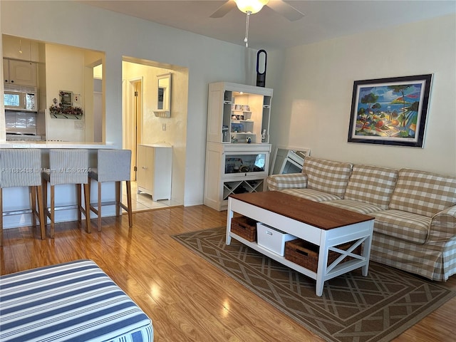 living room with light hardwood / wood-style floors and ceiling fan