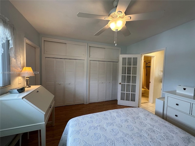 bedroom with two closets, light wood-type flooring, and ceiling fan