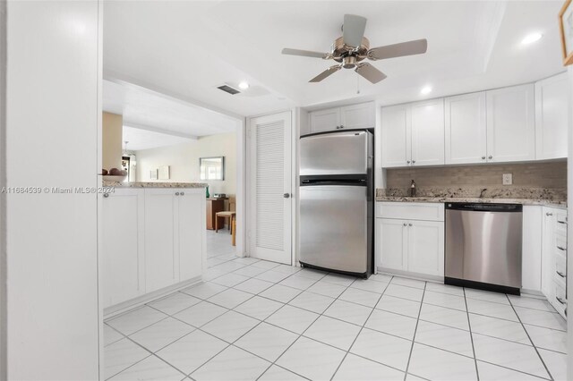 3100 NE 48th St Unit 210, Fort Lauderdale, FL 33308 - kitchen featuring appliances with stainless steel finishes, ceiling fan, tasteful backsplash, light stone countertops, and white cabinets