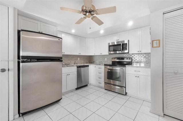 3100 NE 48th St Unit 210, Fort Lauderdale, FL 33308 - kitchen featuring stainless steel appliances, white cabinetry, tasteful backsplash, light stone countertops, and a ceiling fan