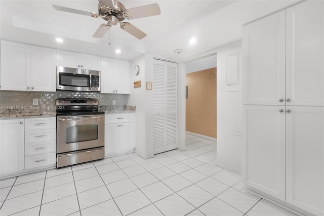 kitchen with white cabinets, decorative backsplash, light stone counters, and appliances with stainless steel finishes