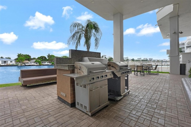 view of patio featuring a water view and grilling area