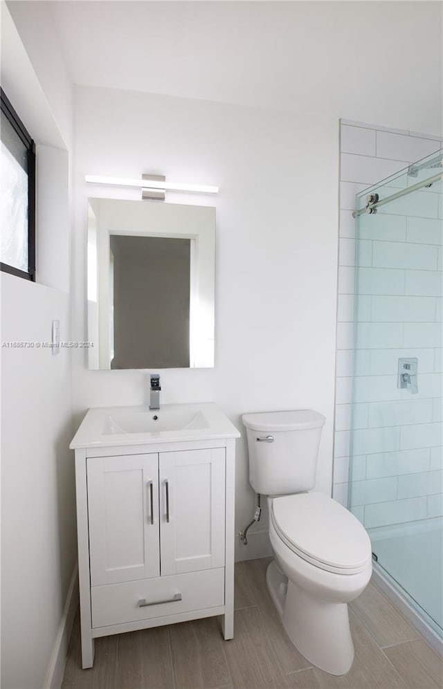 bathroom featuring vanity, tiled shower, and toilet