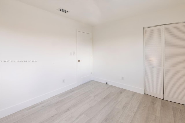 unfurnished bedroom featuring a closet and light hardwood / wood-style flooring