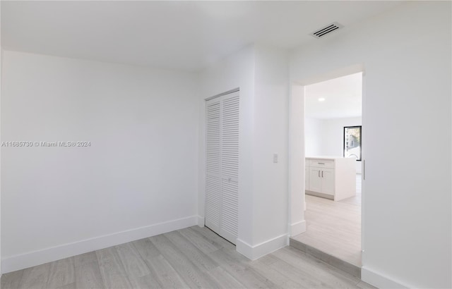 unfurnished bedroom featuring a closet and light hardwood / wood-style floors