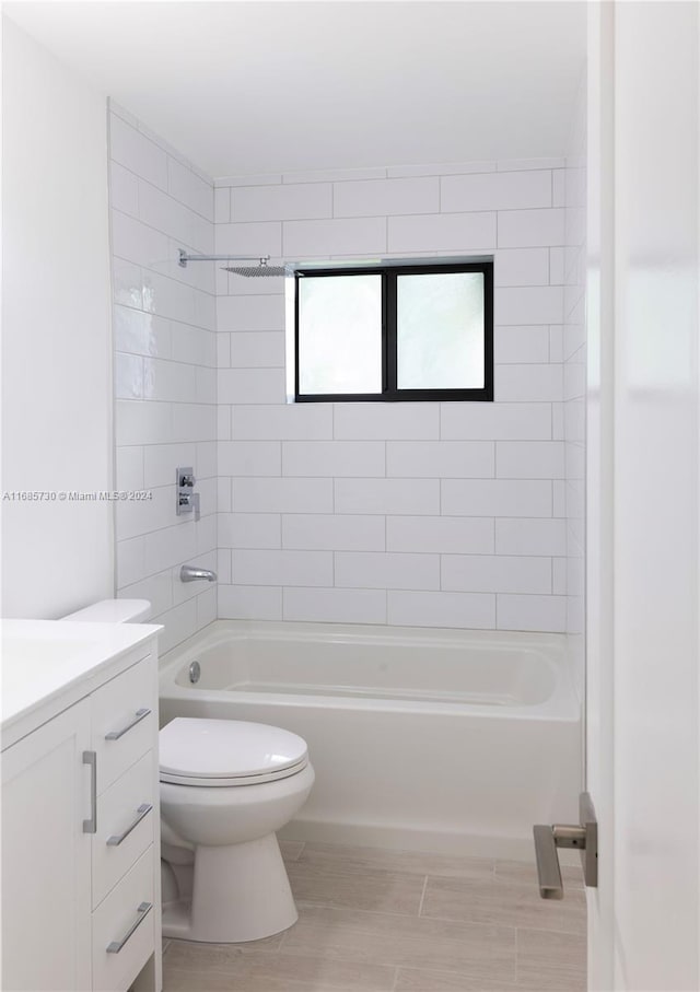 full bathroom featuring vanity, toilet, hardwood / wood-style flooring, and tiled shower / bath