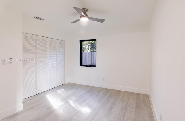 unfurnished bedroom with light hardwood / wood-style flooring, a closet, and ceiling fan