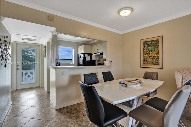 dining room with crown molding and light tile patterned floors