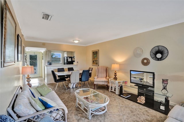 living room with ornamental molding and light tile patterned floors