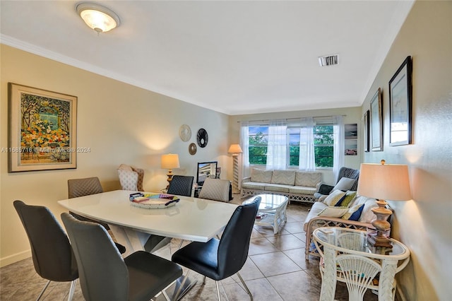 dining space featuring ornamental molding and light tile patterned flooring