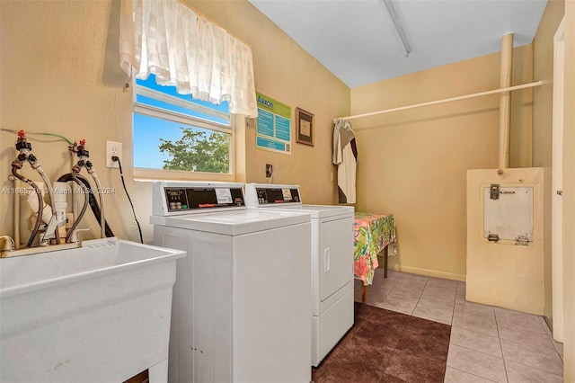 clothes washing area featuring tile patterned floors, sink, and washing machine and dryer