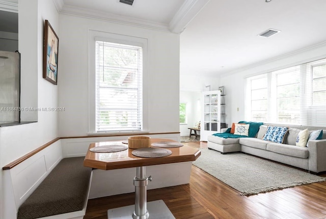 living room with dark wood-type flooring, ornamental molding, and a wealth of natural light