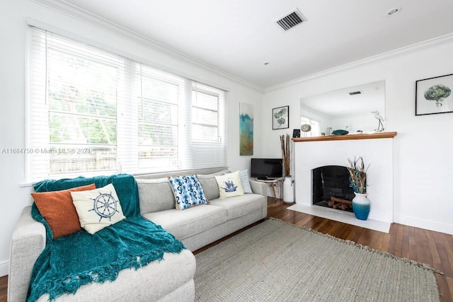 living room with ornamental molding, a healthy amount of sunlight, and hardwood / wood-style flooring