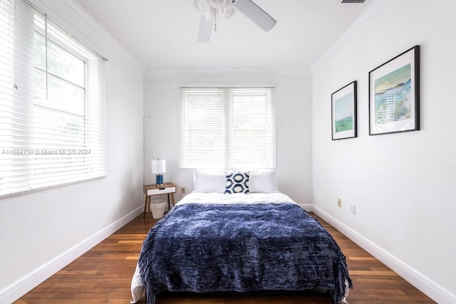 bedroom with dark wood-type flooring, crown molding, and ceiling fan