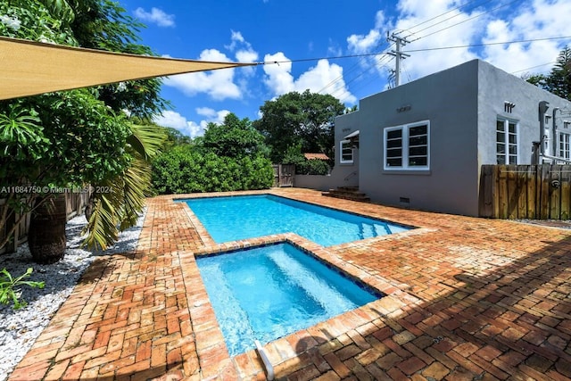 view of pool featuring a patio and an in ground hot tub