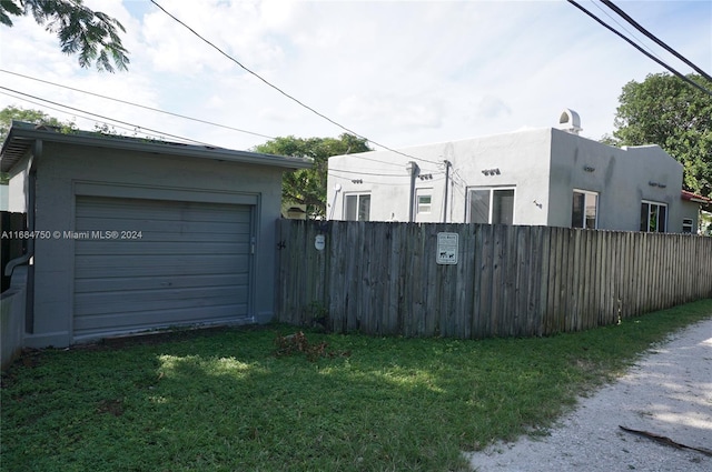 view of property exterior featuring a garage and a lawn