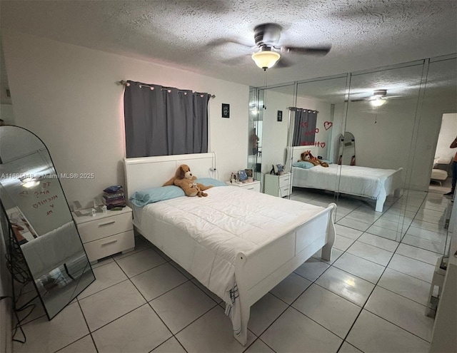 tiled bedroom with ceiling fan, a textured ceiling, and a closet