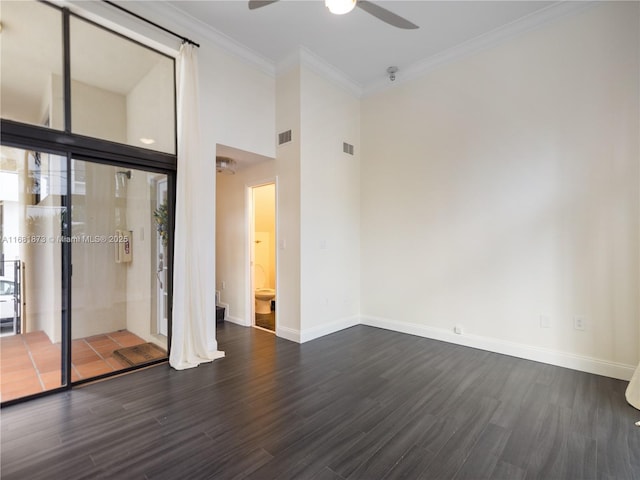 empty room with crown molding, ceiling fan, dark hardwood / wood-style floors, and a high ceiling