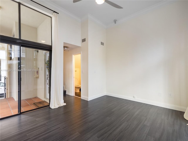 unfurnished room featuring ceiling fan, dark wood-type flooring, baseboards, ornamental molding, and a high ceiling