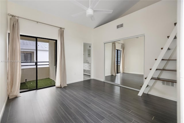 empty room with a towering ceiling, dark hardwood / wood-style floors, and ceiling fan