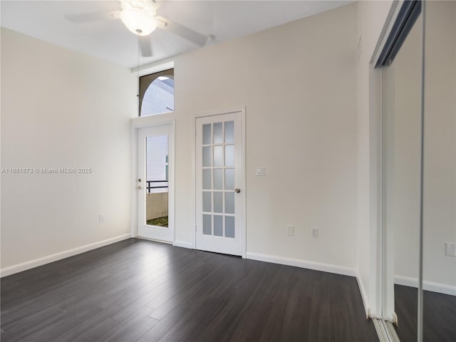 empty room with ceiling fan, dark wood-style floors, and baseboards