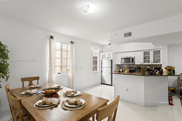 dining room with a textured ceiling and light tile patterned floors