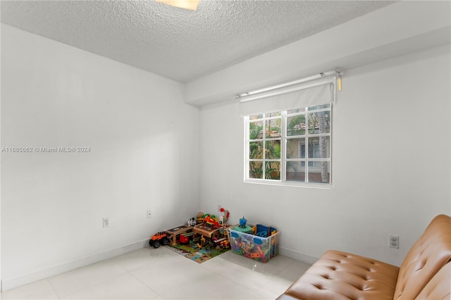 recreation room with a textured ceiling